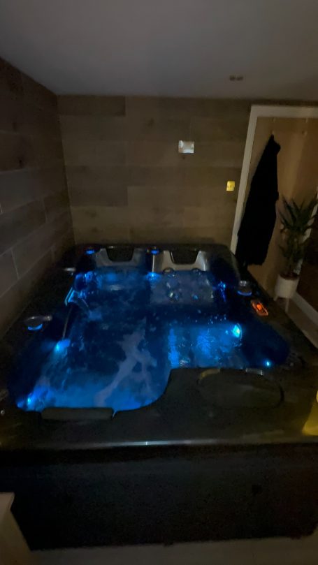 A hot tub with blue lighting in a modern indoor setting.