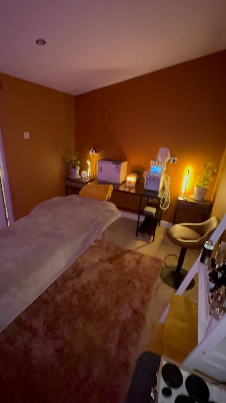 A cozy bedroom with warm lighting, a bed, and a workspace.