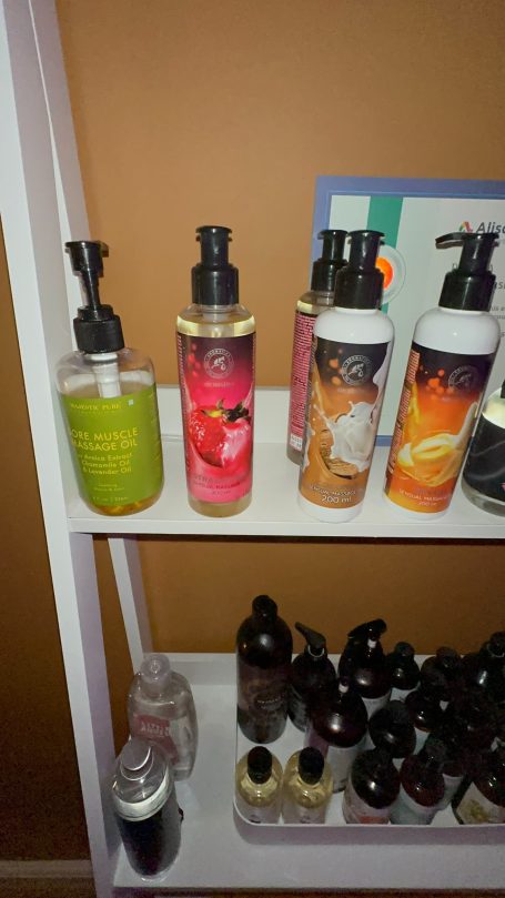 Various bottles of body lotion and skincare products on a shelf.